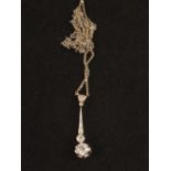 A Gold Diamond drop pendant hung of a White Gold chain,