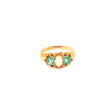 An 18ct Gold three stone ring set with two square cut Emeralds with Opal oval cut centre stone,