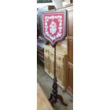 A Victorian Mahogany pole screen with shield tapestry panel