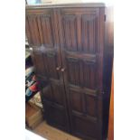 An Oak two door wardrobe with linen fold carving