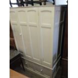 A cream painted single door wardrobe