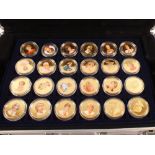 An aluminium case containing fifty eight gold plated and painted Royal commemorative coins