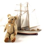 A wooden sailing boat and a Teddy bear