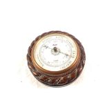 A circular carved Oak aneroid barometer