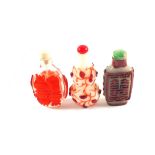 Three Chinese overlaid red glass snuff bottles, one with calligraphy and Jadeite stopper,