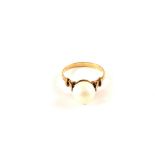 A continental yellow metal ring set with a single Pearl,