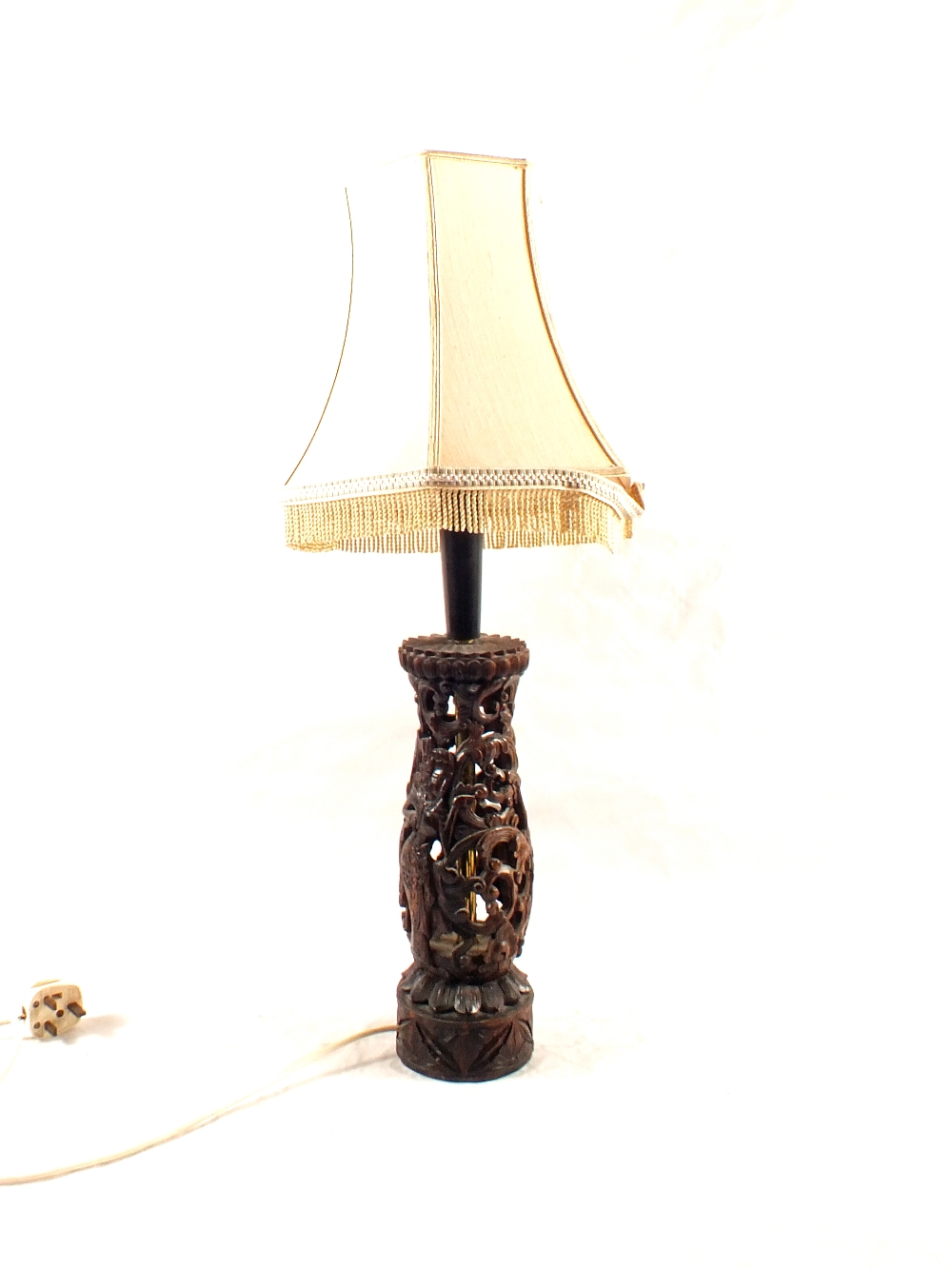 An Indonesian carved hardwood reticulated figure decorated table lamp