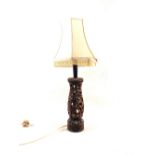 An Indonesian carved hardwood reticulated figure decorated table lamp