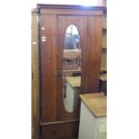 An Edwardian Satinwood oval mirror door wardrobe