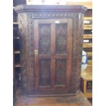 A Victorian carved Oak corner cupboard