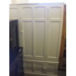 A cream painted single door wardrobe