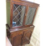 A reproduction Mahogany glazed cabinet with brush slide and two drawers below