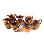 Five Victorian copper lustre jugs and two stoneware harvest jugs (some as found)