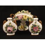 A pair of 19th Century porcelain floral encrusted moon vases and a floral encrusted bowl (handle