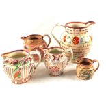 A large 19th Century pink lustre ale jug with floral decoration and motto plus four others (some as