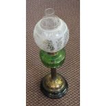 A Brass column oil lamp with green glass font and etched globe