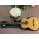 A Suzuki acoustic guitar and a bongo drum,