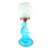 A German blue frosted glass table lamp in the form of a kneeling unclad lady with pineapple shade,