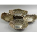 A Victorian silver pedestal dish and three matching dishes, of oval twin handled form embossed