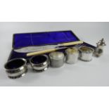 A quantity of silver, comprising three silver napkin rings, two salt cellars with blue glass liners,
