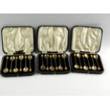 Three sets of Edward VIII silver coffee spoons, with coffee bean terminals, cased and gilt tooled