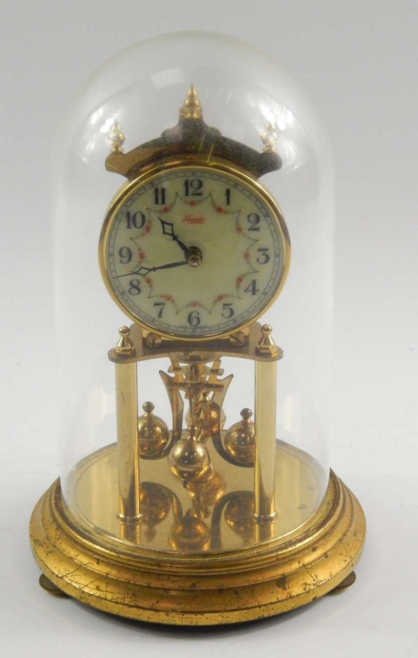 A Kundo brass torsion clock, enamel dial decorated with floral swags, bearing Arabic numerals, 400