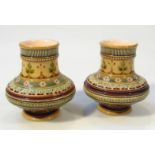 A pair of late 19thC Mettlach vases, each of circular bellied outline, decorated and raised with a