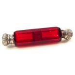 A Victorian cranberry glass double ended scent bottle, the shaped body with silver lids and