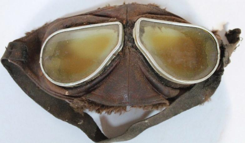 A pair of mid-20thC leather flying goggles, with shape tinted glass centres and elasticated strap,