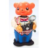 A mid-20thC tin plate clockwork articulated figure, of a bear holding camera, with rubber head in