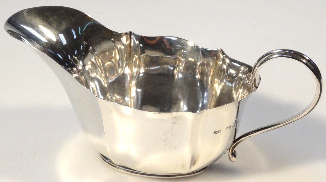 A George VI silver sauce boat, by Josiah Williams & Co. of slipper outline with wavy edge rim and