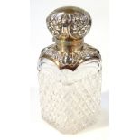 An early 20thC cut glass perfume bottle, with white metal collar and lid of compressed dome form,