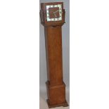 A 1930's walnut veneered granddaughter clock, the 17cm square Arabic dial in a shaped case,