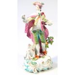 An early 19thC Continental porcelain figure, of a gentleman he standing in finery on a bocage