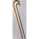 An early 20thC walking cane, with crook end and silver collar and another walking stick, 96cm