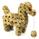 A Folk Art model of a dog, made from Woodbine cigarette packets, with a part pierced body and ball