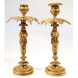 A pair of 20thC brass candlesticks, each with inverted circular urn tops above leafy collars, on