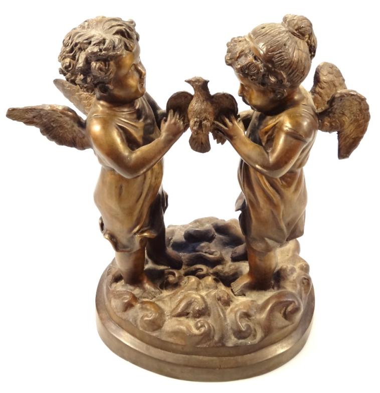 A 20thC bronzed classical figure group, of two cherubs standing holding a bird on a naturalistic - Image 2 of 3