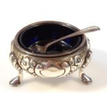 A Victorian silver open salt, the repoussé body decorated with berries and flower heads, on triple