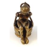 An early 20thC cast metal novelty cigar cutter, formed as a nude lady in seated position on an