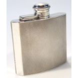 A George V silver hip flask, the shaped body with hinged lid revealing a cork lined interior,