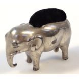 An early 20thC silver plated pin cushion, in the form of a standing elephant with black velvet