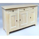 A modern limed oak finish sideboard, the overhanging rectangular top raised above three frieze