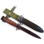 A 20thC US M8A1 dagger bayonet and scabbard, with textured blade, grooved grip and oval end, with