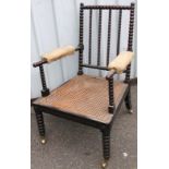 A 19thC polished walnut bobbin turned open armchair, with upholstered arms and deep bergere seat