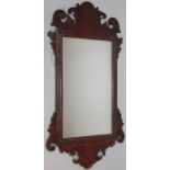 A 19thC mahogany framed fret work mirror, of shaped scroll outline, the central glass with a moulded