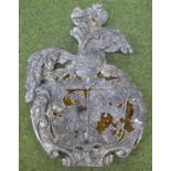 A carved stone coat of arms, in the 16thC style but later, centred by a shield surrounded by