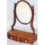 A George III mahogany bow front table mirror, the oval glass with a Sheraton style boxwood outline