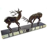 An Art Deco spelter and marbled figure group of rutting deer, on a black ground with coloured marble