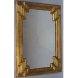 A gilt wood mirror, the rectangular outline heavily carved with Greek key style spandrels, centred